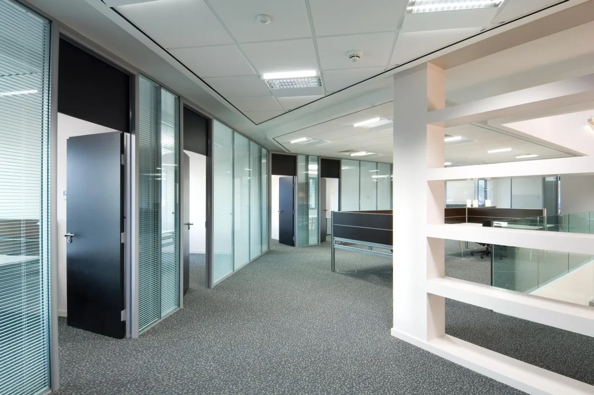 An empty office with glass walls and doors.